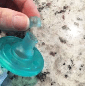 cutting the pacifier tip of a toddler