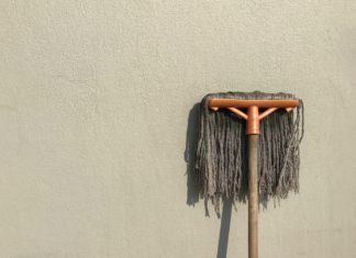 mop leaning against a beige wall