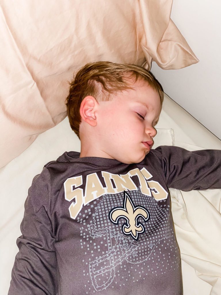 toddler sleeping in his Saints shirt