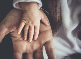 Baby's hand on father's hand