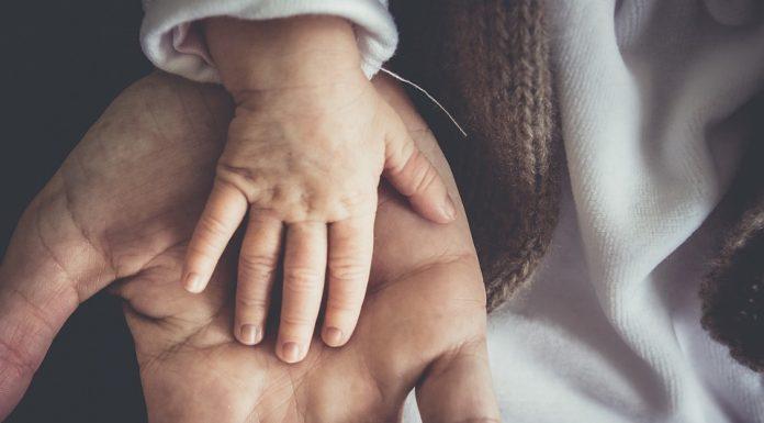 Baby's hand on father's hand